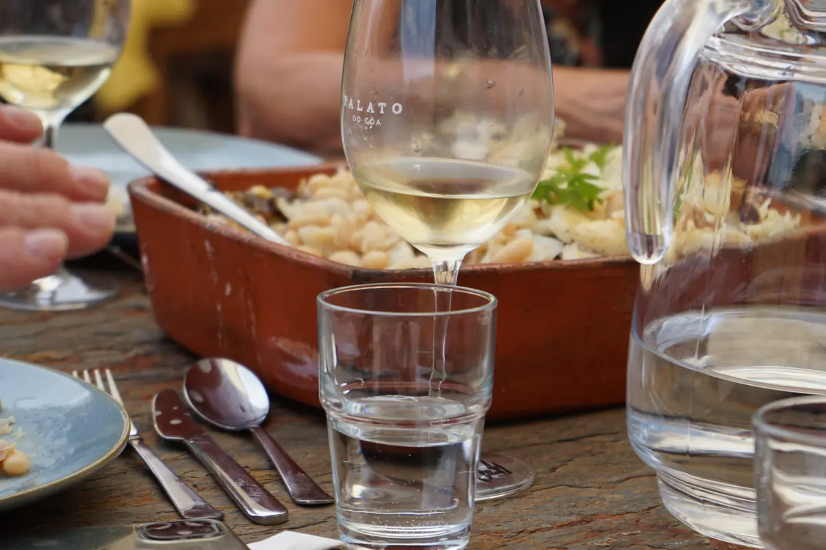 À mesa — vinho branco servido com comida